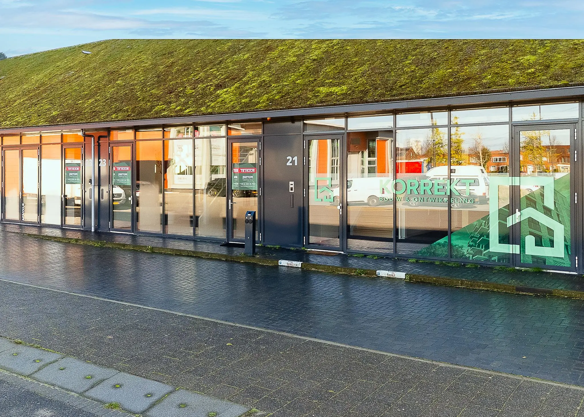 Gebouw met groene mosdak en glazen gevel van Korrekt Bouw & Ontwikkeling aan de Mart Stamhof.
